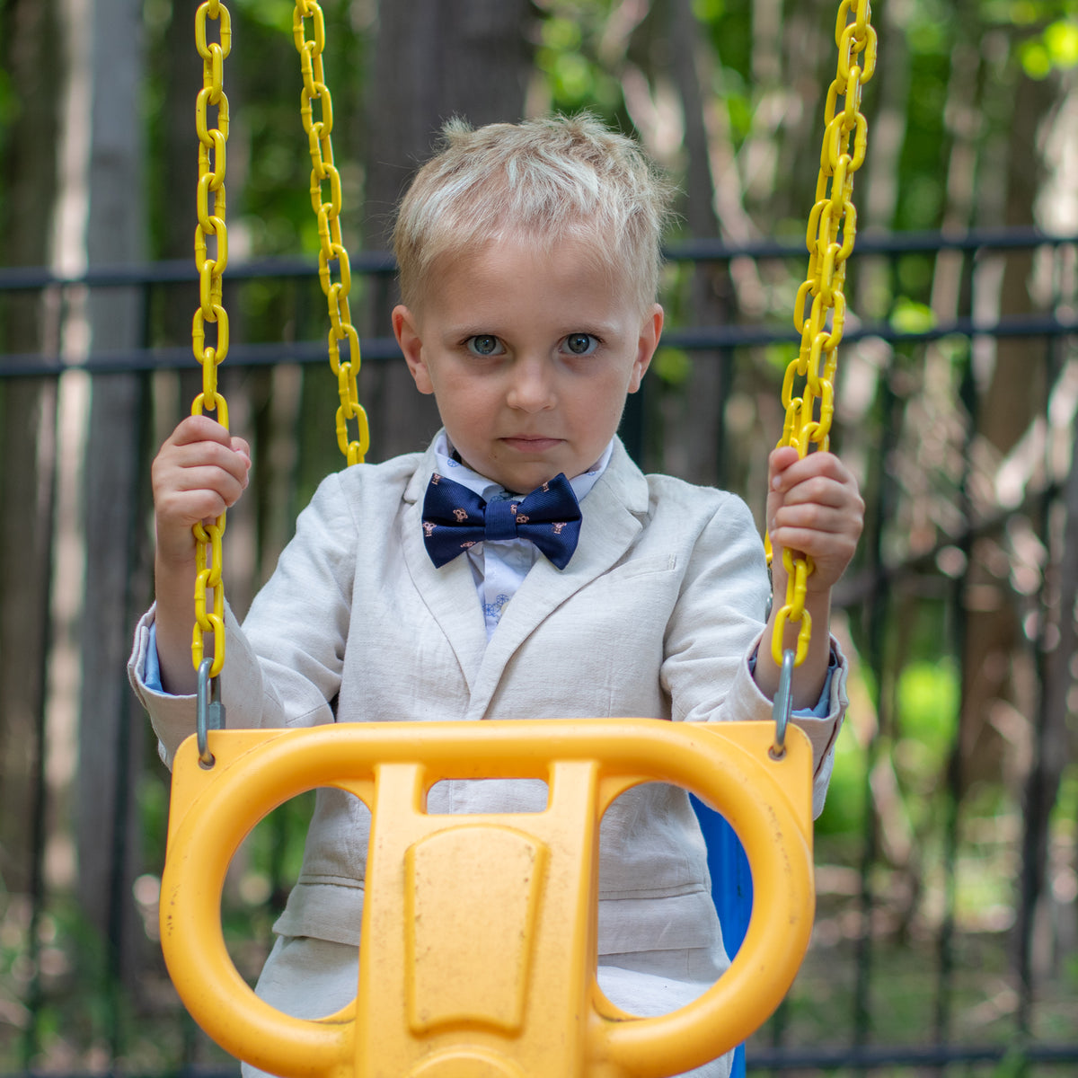 Boy on swing wearing monkey bow tie for kids