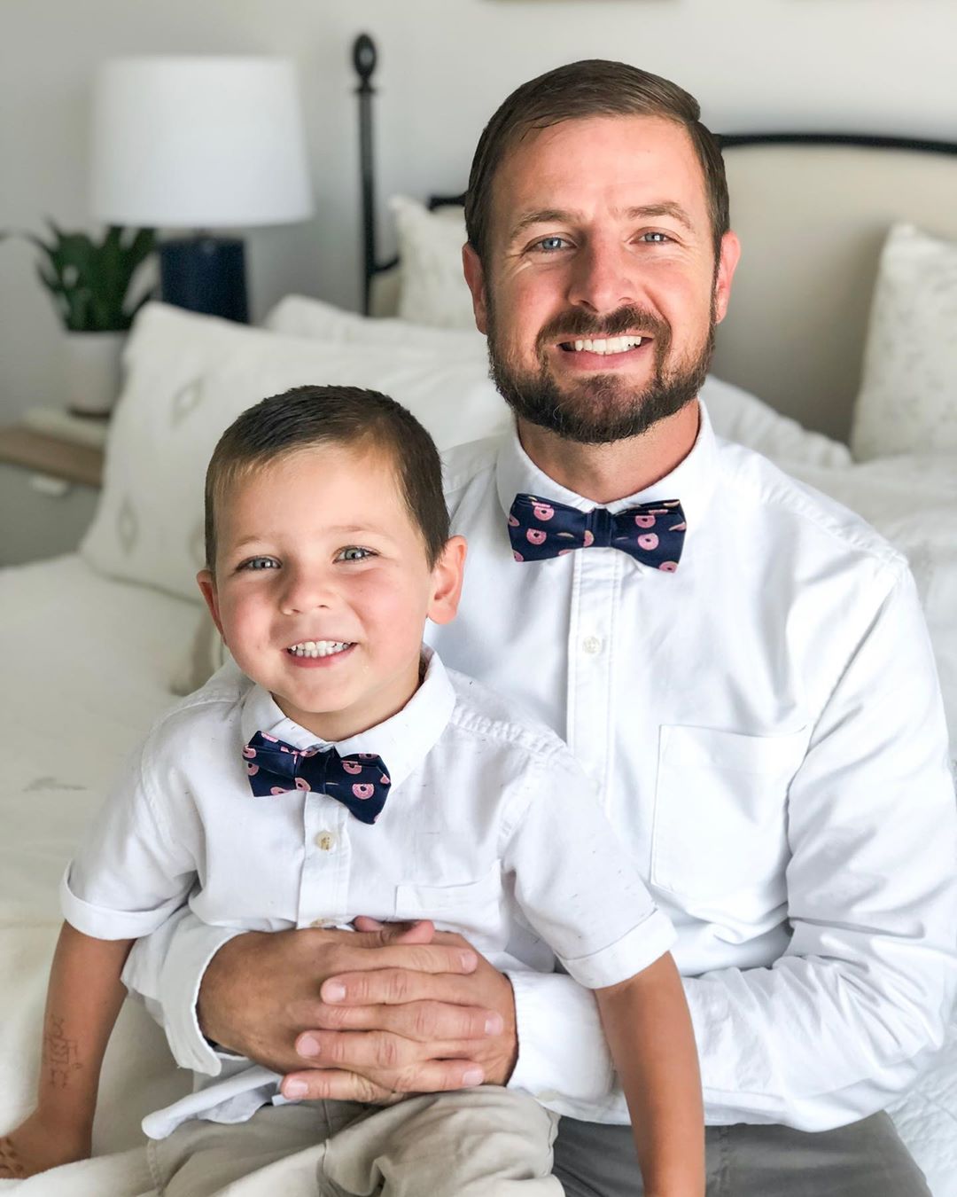 Father and son wearing navy bow ties with pink donuts