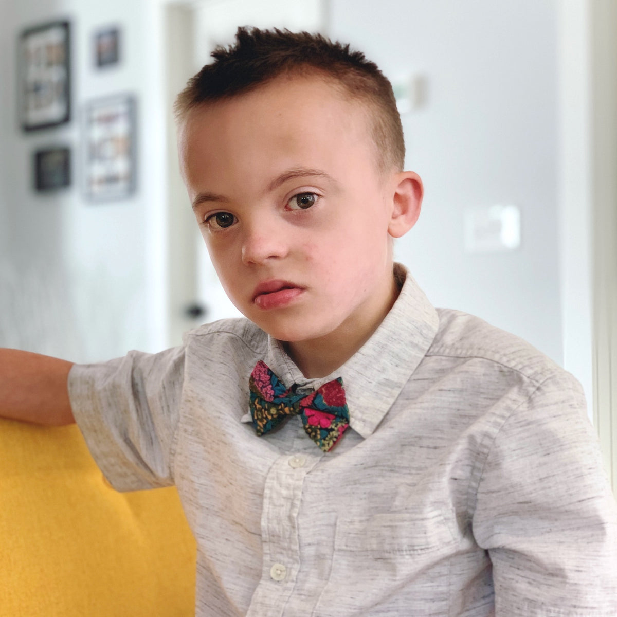 Boy wearing a blue green and pink floral bow tie