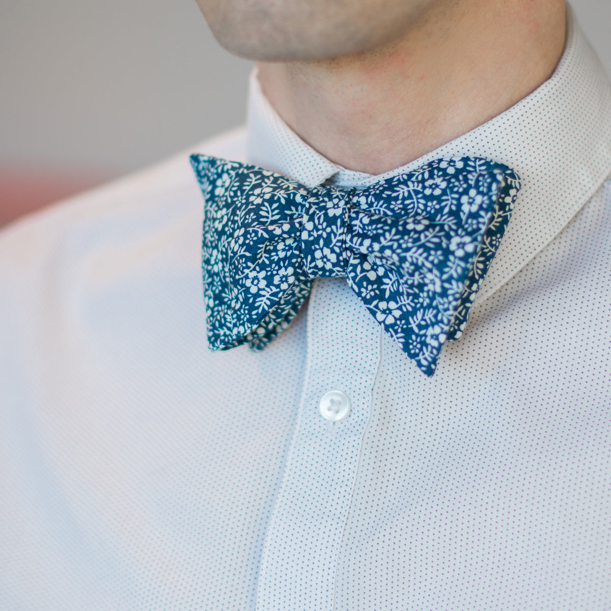 Blue and white floral bow tie with micro-dot white button-down shirt