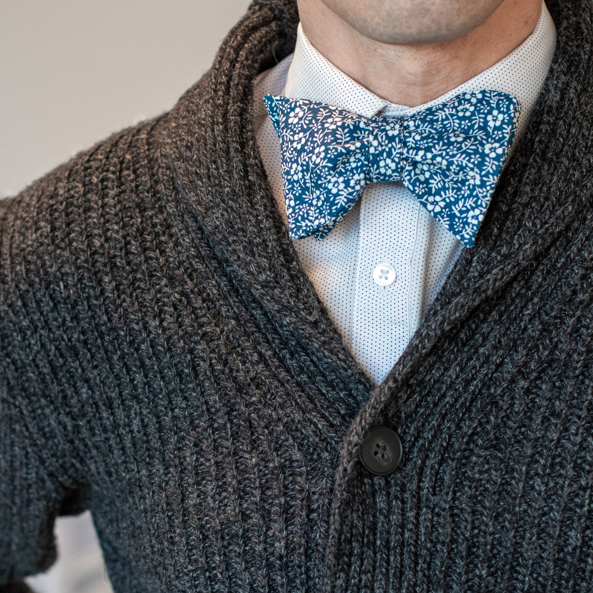 Blue and white floral bow tie with cable knit sweater outfit