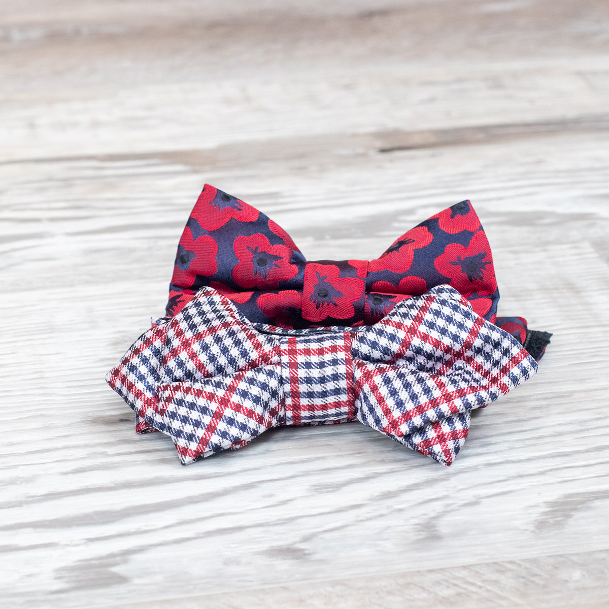 Red poppy floral bow tie on top of wood planks